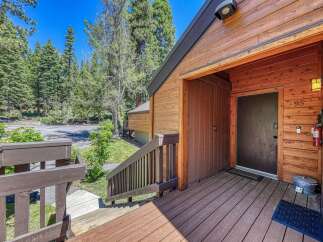 Experience the charm of this mountain retreat, featuring a welcoming wooden deck leading to the entrance.
