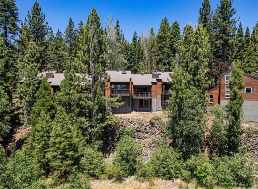 Nestled amidst towering pine trees, this stunning multi-level home offers a unique architectural design with warm wood exteriors and expansive balconies.
