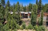 Nestled amidst towering pine trees, this stunning multi-level home offers a unique architectural design with warm wood exteriors and expansive balconies.
