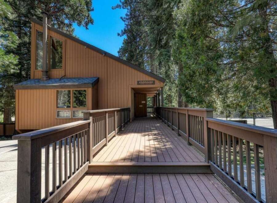 Discover this charming clubhouse, nestled amongst tall trees and accessed by a welcoming wooden deck.
