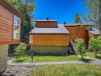 Experience modern mountain living in this beautifully crafted wood-sided home featuring a sleek metal roof and large windows that invite natural light.