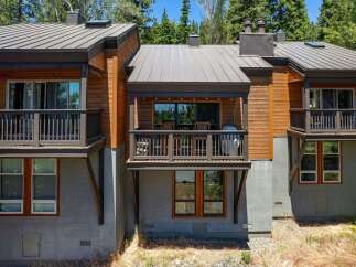 Experience modern mountain living in this stunning property featuring a sleek metal roof and warm wood siding.