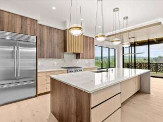 Experience modern luxury in this stunning kitchen, featuring sleek stainless steel appliances and a spacious island with a marble countertop.