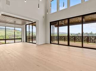 Experience modern luxury in this spacious living area featuring soaring ceilings and expansive windows that flood the space with natural light.