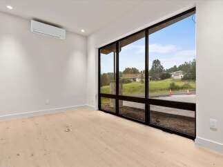 Experience modern living in this bright and airy room featuring a sleek mini-split AC unit for optimal comfort.