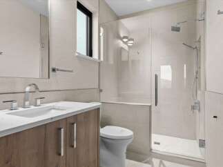 Experience modern luxury in this stunning bathroom, featuring a sleek vanity with a marble countertop and ample storage.