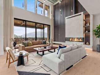 Experience luxurious living in this stunning modern living room, featuring a grand fireplace and expansive windows with breathtaking mountain views.