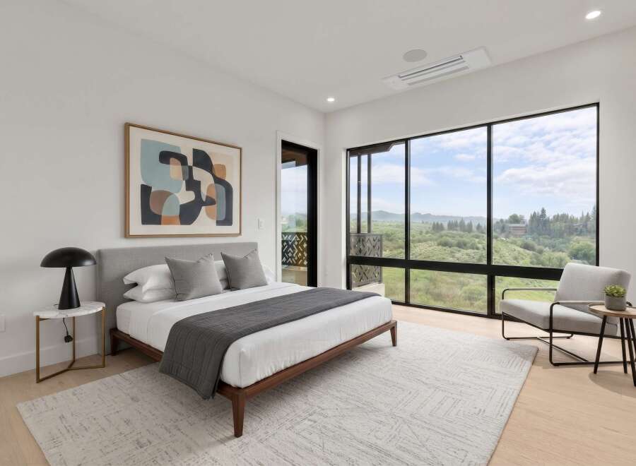 Experience modern luxury in this stunning bedroom featuring a king-sized bed, complemented by a large abstract artwork and expansive windows offering breathtaking views.