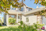 Charming two-story home featuring a welcoming front porch with a white column and a classic lantern.
