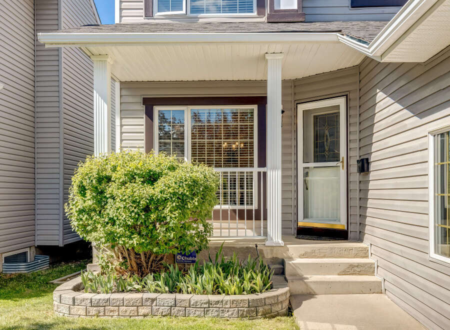Charming home featuring a welcoming covered porch with white columns, perfect for enjoying your morning coffee.