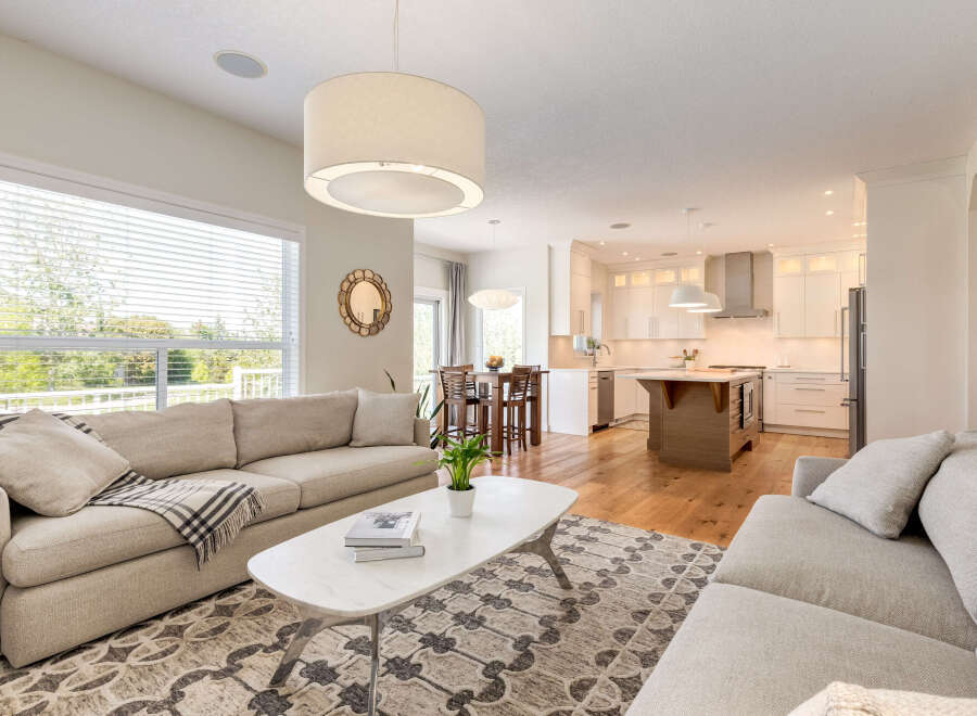Experience open-concept living in this beautifully appointed home, featuring a spacious living area seamlessly flowing into a modern kitchen.