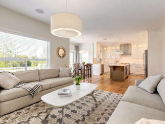 Experience open-concept living in this beautifully appointed home, featuring a spacious living area seamlessly flowing into a modern kitchen.