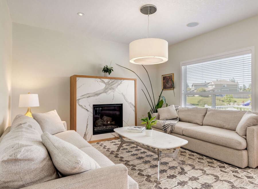 Experience modern living in this beautifully appointed living room, featuring a striking marble fireplace as the centerpiece.