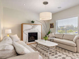 Experience modern living in this beautifully appointed living room, featuring a striking marble fireplace as the centerpiece.