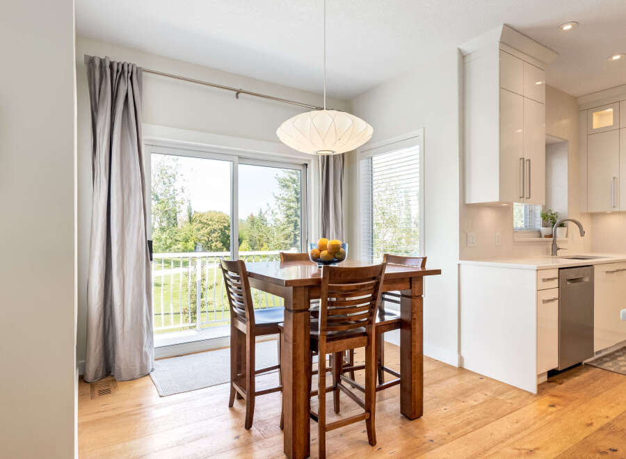 Enjoy bright and airy living with this open-concept dining area, featuring a stylish wooden table and chairs perfect for intimate meals.