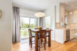 Enjoy bright and airy living with this open-concept dining area, featuring a stylish wooden table and chairs perfect for intimate meals.