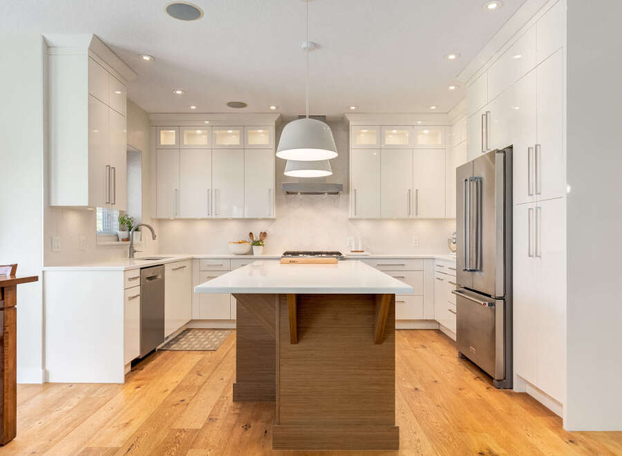 Experience modern luxury in this stunning kitchen, featuring sleek white cabinetry and a spacious island perfect for entertaining.