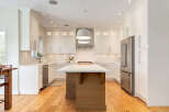 Experience modern luxury in this stunning kitchen, featuring sleek white cabinetry and a spacious island perfect for entertaining.