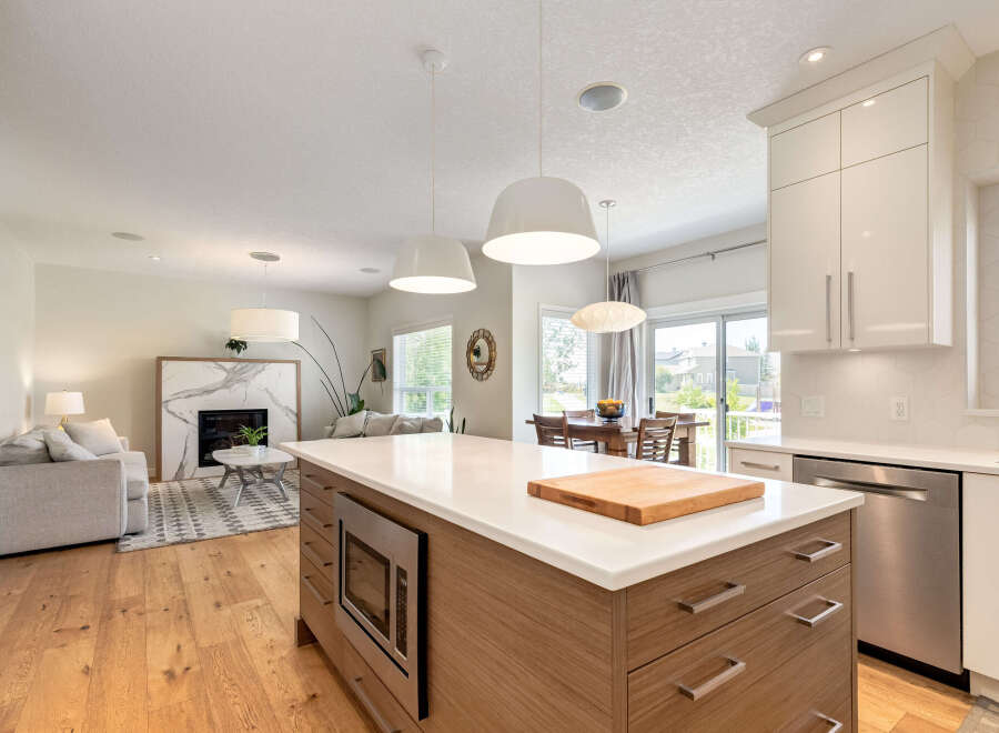 Experience modern living in this open-concept home featuring a sleek kitchen island with a built-in microwave and ample storage.