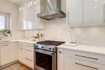 Experience modern elegance in this stunning kitchen, featuring sleek white cabinetry and a chic hexagonal tile backsplash.