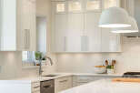 Experience modern elegance in this stunning kitchen, featuring sleek white cabinetry and a chic hexagonal tile backsplash.