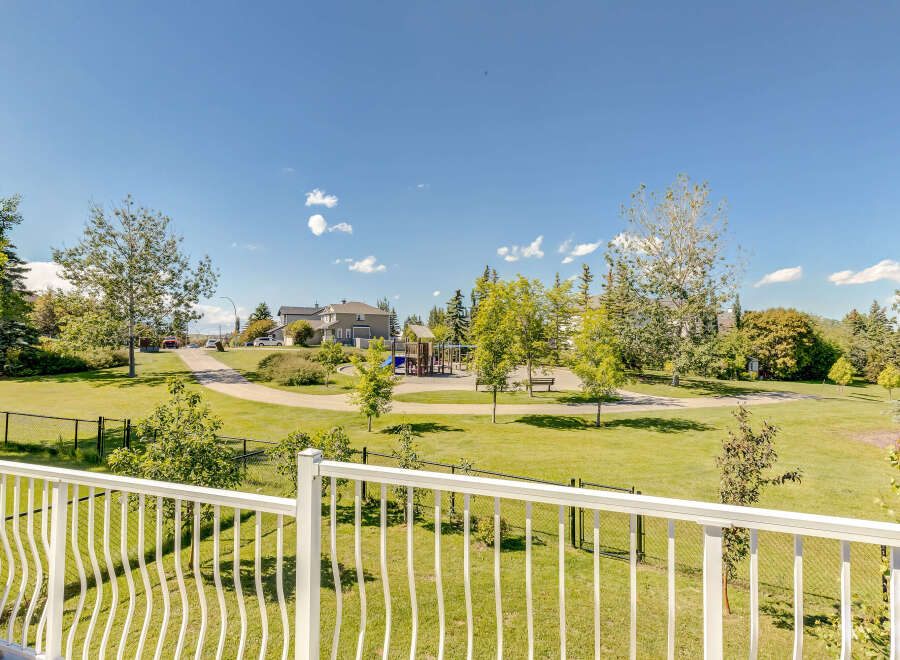 Enjoy the beautiful park-like setting from your private balcony, overlooking a vibrant green space with a playground and walking paths.