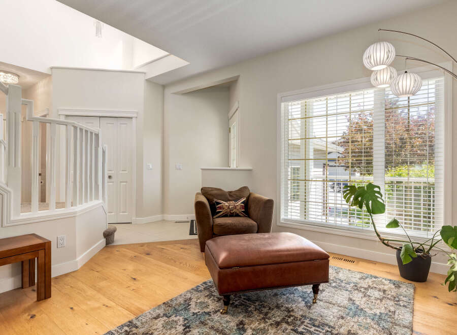 Step into this inviting living space featuring a cozy brown armchair and ottoman, perfect for relaxation.