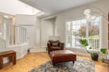 Step into this inviting living space featuring a cozy brown armchair and ottoman, perfect for relaxation.