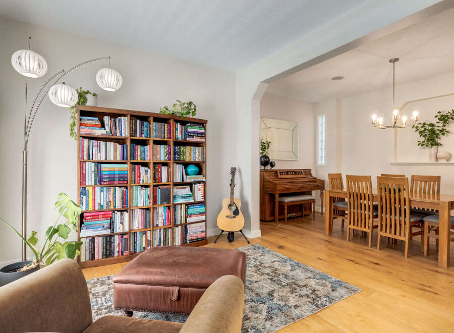 This inviting living space features a large, well-stocked bookshelf and a comfortable leather ottoman, perfect for cozy evenings.