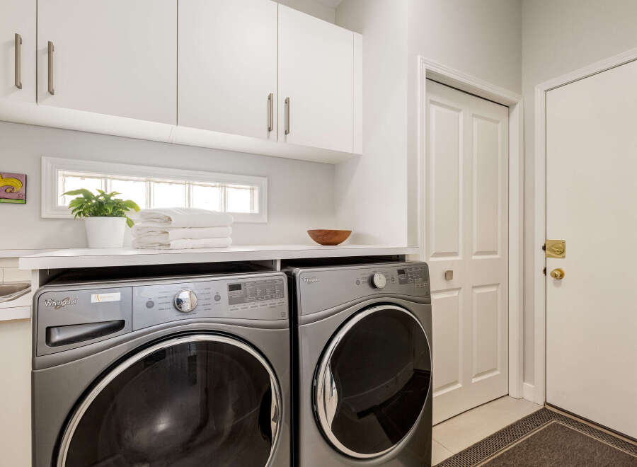 This laundry room features a modern Whirlpool washer and dryer set, perfect for handling all your laundry needs.