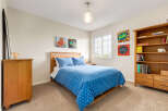 This charming bedroom features a cozy wooden bed with a playful blue star-patterned duvet, complemented by a matching pillow.