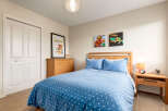 This charming bedroom features a cozy queen-size bed adorned with a playful blue star-patterned duvet and matching pillows.