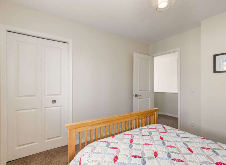 This charming bedroom features a cozy bed with a colorful quilt, perfect for a restful night's sleep.