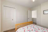 This charming bedroom features a cozy bed with a colorful quilt, perfect for a restful night's sleep.