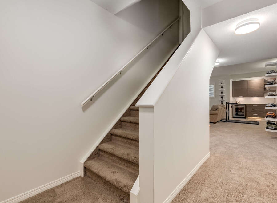 Discover this beautifully appointed basement featuring a modern wet bar with sleek cabinetry and a beverage cooler, perfect for entertaining.