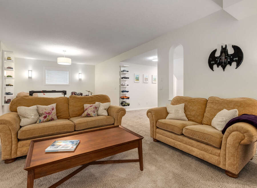 This inviting living space features two plush, golden-hued sofas perfect for relaxation, complemented by a warm wooden coffee table.