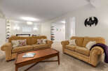 This inviting living space features two plush, golden-hued sofas perfect for relaxation, complemented by a warm wooden coffee table.
