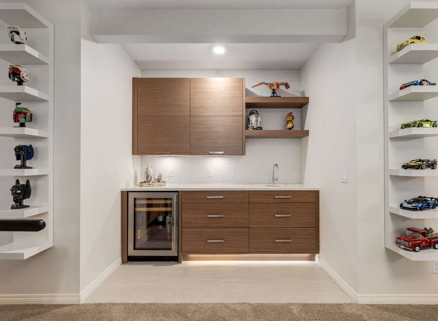 This modern home bar features sleek, dark wood cabinetry and a built-in wine fridge, perfect for entertaining.