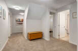 This hallway features a warm and inviting atmosphere with plush carpeting and modern ceiling lights.