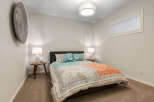 This inviting bedroom features a comfortable queen-size bed adorned with a vibrant, patterned duvet and decorative pillows.