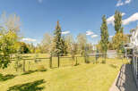 Enjoy the outdoors in this beautifully maintained backyard, complete with a lush green lawn and mature trees providing ample shade.