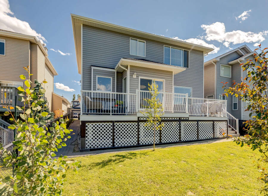 Enjoy outdoor living on this spacious deck with white railings, perfect for entertaining or relaxing.