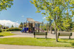 Enjoy outdoor fun in this vibrant community playground, featuring a multi-level play structure with slides and climbing elements.