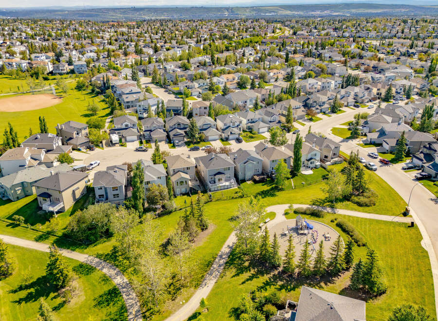 Discover this stunning aerial view of a well-maintained suburban neighborhood, showcasing a variety of modern homes with manicured lawns and mature trees.