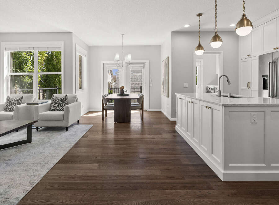 Experience modern living in this open-concept space, featuring a sleek kitchen with a large island and stainless steel appliances.