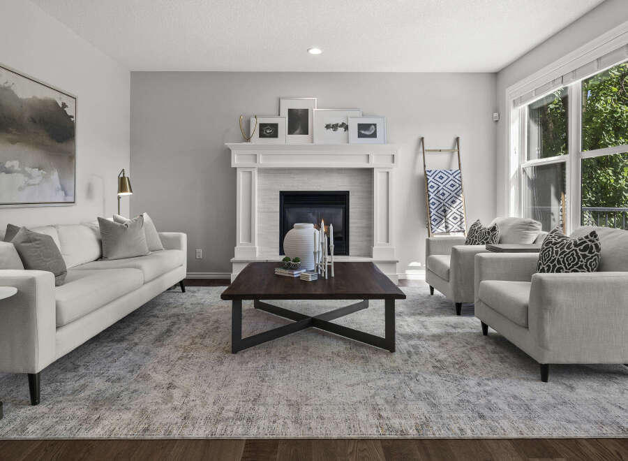 Step into this inviting living room, featuring a cozy fireplace and a large sectional sofa perfect for family gatherings.