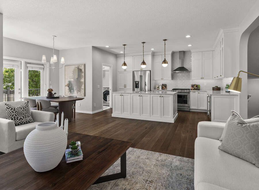 Experience modern living in this stunning open-concept home, featuring a gourmet kitchen with a large island and sleek white cabinetry.