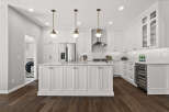 Experience luxury in this stunning white kitchen, featuring a spacious island with ample cabinet storage and elegant marble countertops.