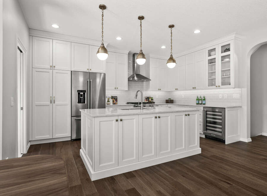 Experience luxury in this stunning modern kitchen, featuring sleek white cabinetry, a spacious marble-topped island, and high-end stainless steel appliances.