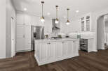 Experience luxury in this stunning modern kitchen, featuring sleek white cabinetry, a spacious marble-topped island, and high-end stainless steel appliances.